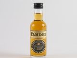 a close up of a bottle of whisky on a white surface