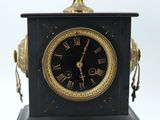a black and gold clock sitting on top of a table