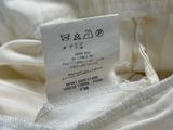 the label of a white dress is displayed on the back of the dress