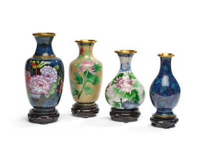 trois vases décorés de fleurs sont posés sur un support