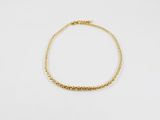 un bracelet en or avec un motif de tresse sur fond blanc
