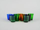 plusieurs verres à shot de différentes couleurs alignés sur une surface blanche