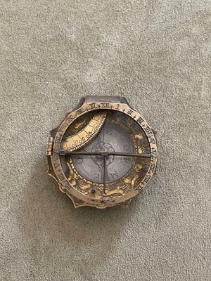 une horloge accrochée au mur sur laquelle figure une boussole