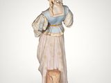 a figurine of a woman in a blue dress holding a dog