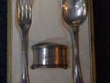 a silver spoon and fork in a box on a table
