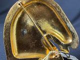 a gold horse head sculpture on a black stand