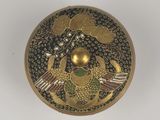 a close up of a gold and black box on a white surface