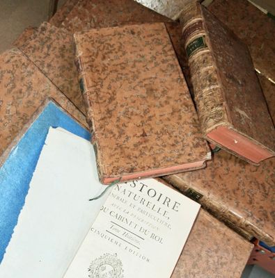 many old books on a table with papers on it