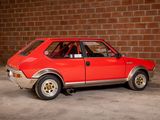a red car that is parked in front of a brick wall