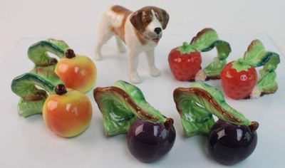 plusieurs figurines représentant des chiens et des fruits sur un fond blanc