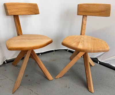 une paire de chaises en bois placées l'une à côté de l'autre sur un sol en béton