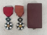 two medals and a book on a white surface