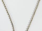 a close up of a necklace on a white surface