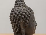 statue of a head of a woman with curly hair on a wooden table
