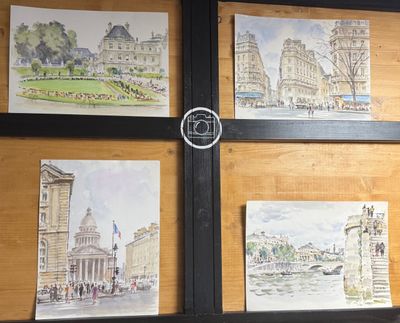 quatre tableaux accrochés au mur d'un immeuble sur lequel se trouve une horloge