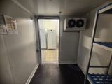 une petite pièce avec des étagères et une porte donnant sur une salle de bains