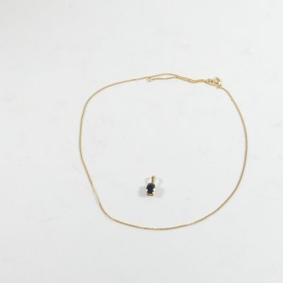 un collier en or orné d'une pierre noire et d'une chaîne en or