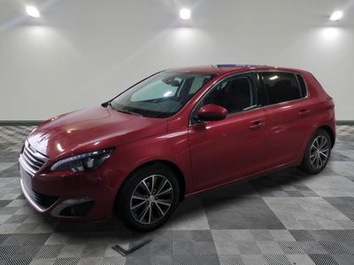 une voiture rouge garée dans un garage au sol en damier