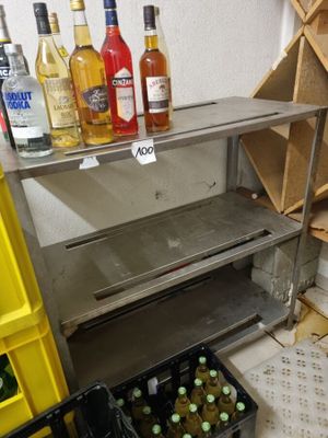 de nombreuses bouteilles d'alcool posées sur une étagère dans une pièce