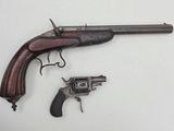 a close up of a gun and a revolver on a white surface