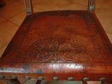 a wooden chair with a leather seat on a tile floor