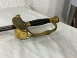 a gold and black sword on a white surface
