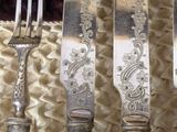 four forks and a knife on a table with a basket