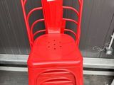 une pile de chaises rouges devant un mur gris