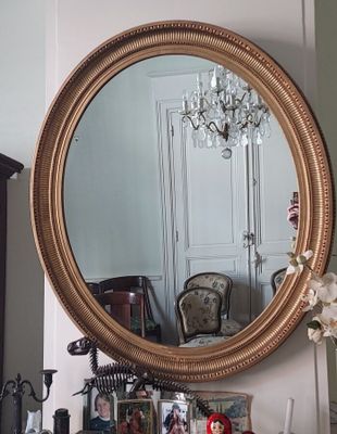 a mirror that is sitting on a dresser in a room