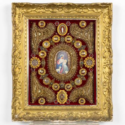 un cadre doré richement décoré, dans lequel figure le portrait d'une femme et d'un enfant