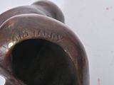 a bronze statue of a man with a hat on it ' s head