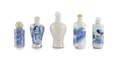 six vases bleus et blancs sont alignés sur une surface blanche