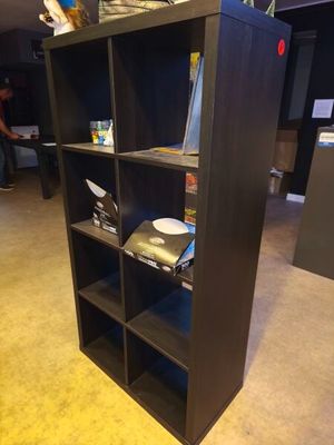 a black bookcase that has a lot of books on it
