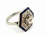 a close up of a diamond and sapphire ring on a white background