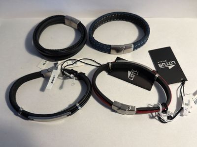 trois bracelets en cuir noir et rouge posés sur une surface blanche