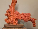 Figurine chinoise sculptée représentant une femme et un dragon, posée sur un socle en bois
