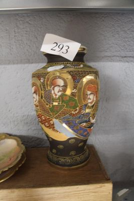 un vase posé sur une étagère à côté d'une assiette