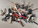 a pile of assorted watches sitting on a table