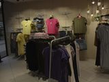 a lot of clothes hanging on a rack in a store