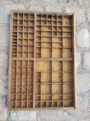 une vieille boîte de machine à écrire en bois posée contre un mur de pierre