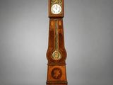 une horloge de parquet qui se trouve au milieu de la pièce