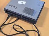 a laptop computer sitting on a table with a charger plugged into it
