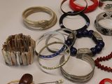 many different types of bracelets and rings on the table