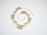 an image of a silver necklace and bracelet on a white surface
