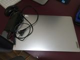 un ordinateur portable posé sur un bureau, à côté d'un clavier et d'une souris