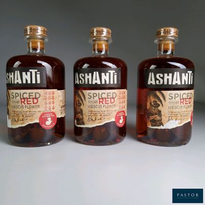 three bottles of alcohol are lined up on a white surface