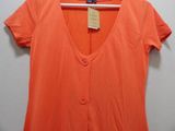 a close up of an orange shirt hanging on a hanger