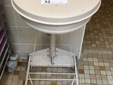 a white toilet sitting in a bathroom next to a trash can