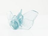 a small glass object with a butterfly on top of it