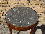 a small table with a marble top on a sidewalk